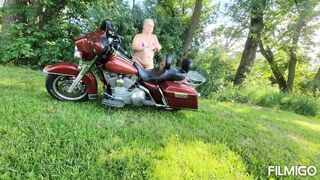 Wife posing with harley outdoors.