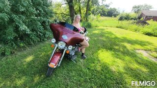 Wife posing with harley outdoors.