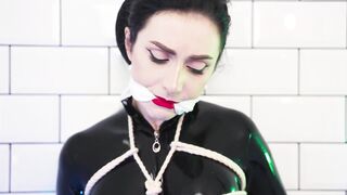 Goddess in latex catsuit tied with ropes